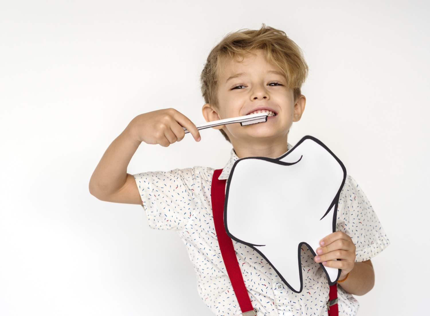 Bambino con modello di dente gigante e spazzolino – educazione all'igiene orale